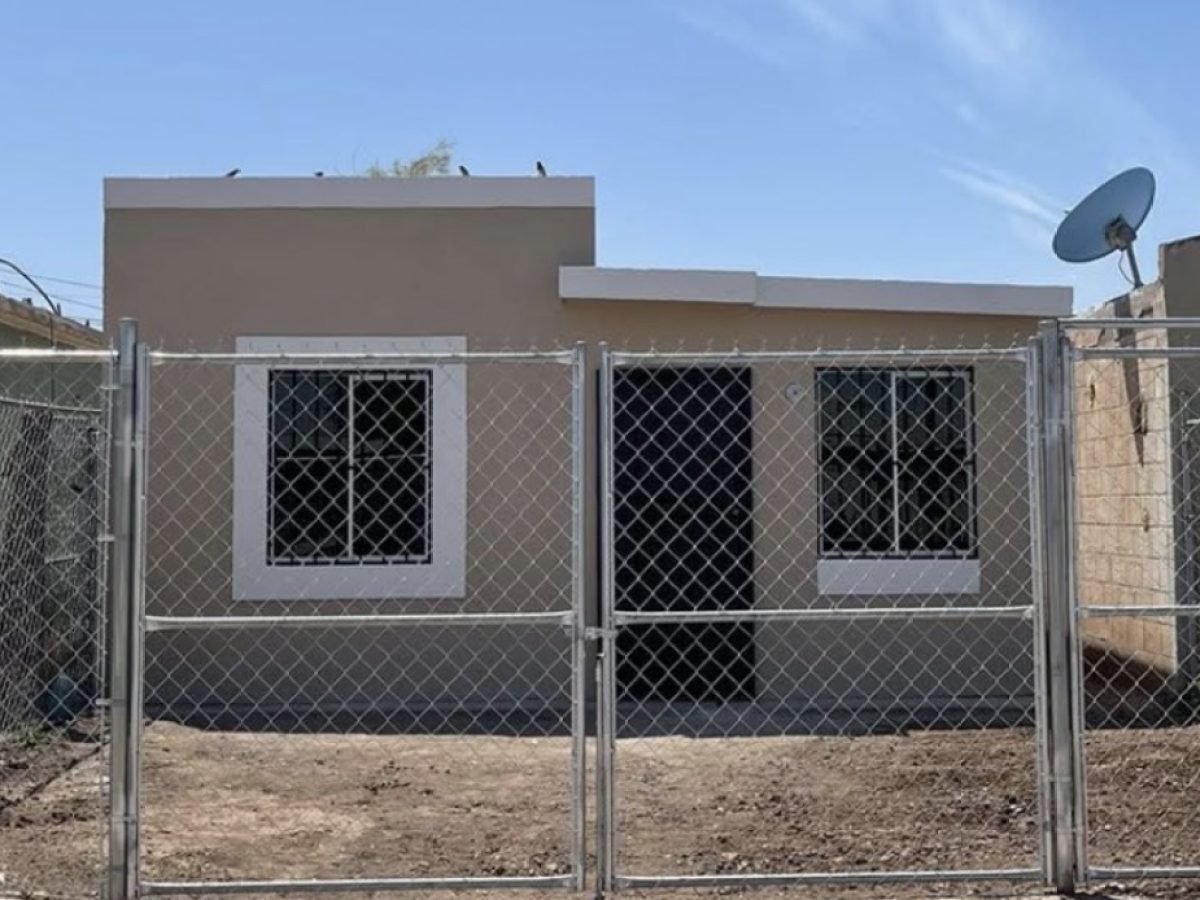 Después: la misma casa rehabilitada, pintada, con puerta, ventanas con protección y cerco nuevo